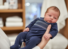 Load image into Gallery viewer, Baby boy in navy smocked babygrow - held in arms