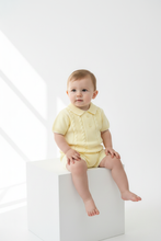 Load image into Gallery viewer, Baby boy in yellow cable-knit set on white block