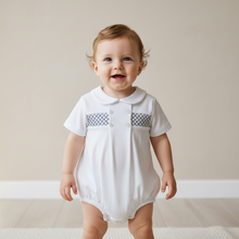 Load image into Gallery viewer, Baby boy standing in white smocked romper - natural