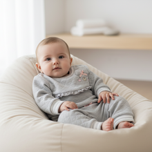 Load image into Gallery viewer, Baby girl in grey bear outfit - cream beanbag