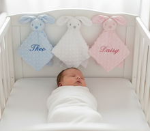 Load image into Gallery viewer, Baby in crib - front view with three bunny comforters
