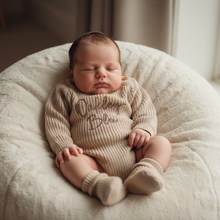Load image into Gallery viewer, Baby propped on cream beanbag in Oakley romper
