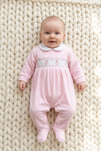 Load image into Gallery viewer, Baby wearing the pink smocked sleepsuit on an ivory chunky-knit blanket