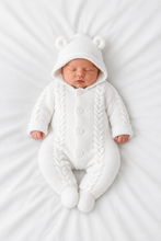 Load image into Gallery viewer, Newborn in the pure white pramsuit lying flat on white bedding, shot from above