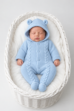 Load image into Gallery viewer, Sleeping newborn in the blue pramsuit lying in a white wicker basket
