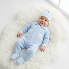 Load image into Gallery viewer, Smiling baby in blue on a white fluffy rug