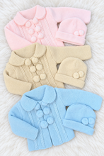 Load image into Gallery viewer, Three baby knit sets on a white fluffy rug, example one
