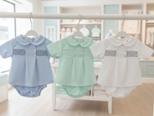 Load image into Gallery viewer, Three baby outfits on hangers in baby boutique