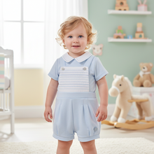 Load image into Gallery viewer, Toddler boy in pale blue smocked romper - nursery setting